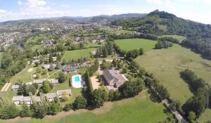 uma vista aérea de uma grande propriedade com uma casa e árvores em Aux Portes des Monts d'Aubrac em Espalion