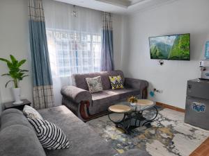 a living room with a couch and a table at Kioka gardens 1&2 bedroom- with wifi and parking in Nanyuki