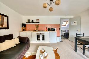 een woonkamer met een bank en een tafel bij Le Charmant in Lannion