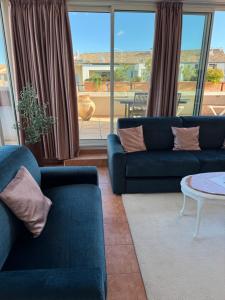 a living room with two blue couches and a table at Penthouse - Jacuzzi - Terrace - Parking - 2 pools in Antibes +37 photos