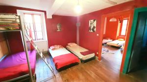 a room with bunk beds in a room with red walls at les Spartiates in Seix