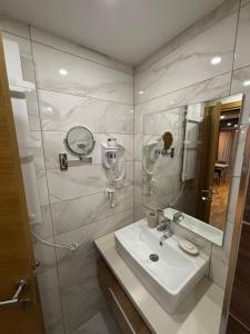 a white bathroom with a sink and a mirror at Golden Hour in Kopaonik +82 photos