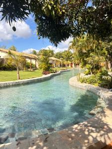 a pool of water in a park with trees at La Belle Resort Lago Azul in Nísia Floresta