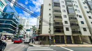 a busy city street with a tall white building at 200 metros da Praia Central na Avenida Brasil próximo à Roda Gigante e Shopping Atlântico in Balneário Camboriú