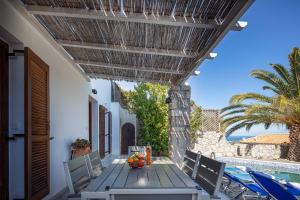 a wooden table with a bowl of fruit on a patio at Villa Delfi with private pool in Agia Triada
