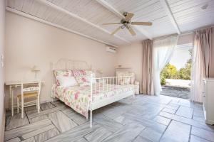 a bedroom with a bed and a ceiling fan at Corinthian Blue Retreat in Katakoúli +48 photos