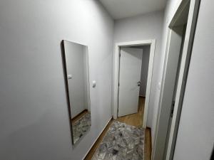 un corridoio con uno specchio sul muro e una porta di Apartment Amistad Novi Sad a Novi Sad