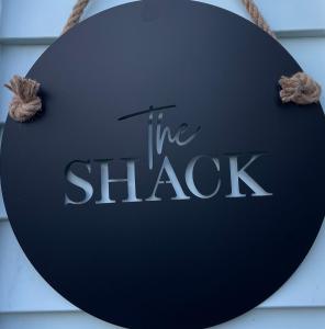 a sign that reads the shack hanging on a building at The Shack in Christchurch