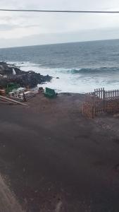 una spiaggia con l'oceano e una recinzione in legno di Tranquilidad frente al mar a Güímar