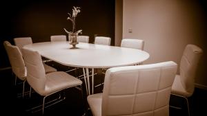 a white table with chairs and a vase with flowers on it at Hotell Nivå in Boden +12 photos