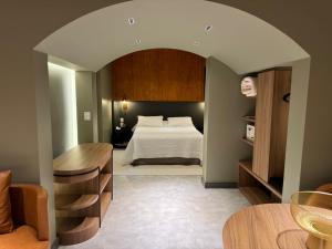 a bedroom with a bed and a table in a room at Mogano Premium Hotel - ELETROPOSTO in Chapecó +122 photos