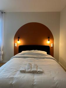 a bed with two white towels on top of it at Chambre privée "Nuage du matin" - Cuisine partagée in Amiens