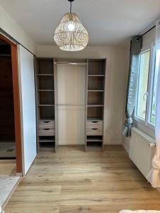 a walk in closet with a chandelier at Chambre privée "Nuage du matin" - Cuisine partagée in Amiens