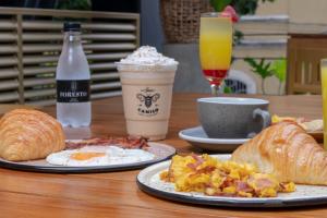 two plates of breakfast food and drinks on a table at Hotel Foresto 365 in Cali