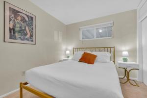 a bedroom with a white bed and a painting on the wall at Retro 50's mid century modern home in Tucson