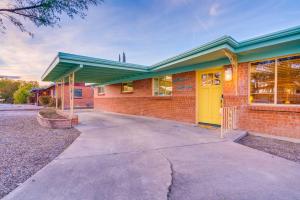 a brick building with a yellow door on a street at Retro 50's mid century modern home in Tucson