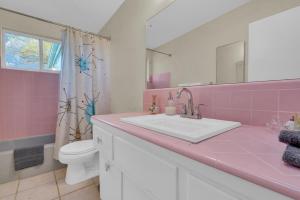 a pink bathroom with a sink and a toilet at Retro 50's mid century modern home in Tucson +32 photos
