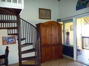 a room with a staircase and a wooden cabinet at Molokai Kepuhi Beach Gem in Kepuhi