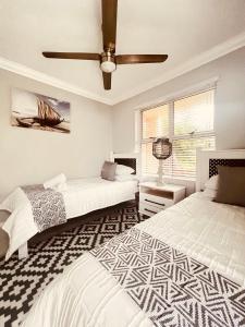 a bedroom with two beds and a ceiling fan at 13 Chesapeake Bay in Margate +22 photos