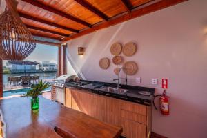 a kitchen with a counter with a sink and a window at Bahia Soul - Casa Cali - Barra Grande - Península de Maraú in Barra Grande