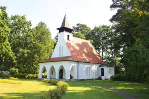 a white church with a steeple on a grass field at Balkon, gratis Nutzung vom AHOI Erlebnisbad und Sauna in Sellin - Appartemenmt Nordwind in Baabe +12 photos