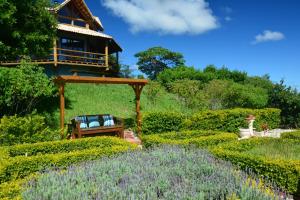 a garden with a bench and a house in the background at Pousada Quinta da Serra in Cunha +49 photos