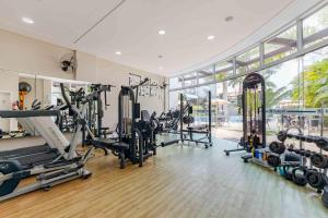 a gym with treadmills and machines in a room at Apartamento em Condomínio com Piscina e Jacuzzi - Boulevard Bombinhas in Bombinhas