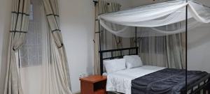 ein Schlafzimmer mit einem Himmelbett in der Unterkunft Mara Home 2 in Arusha