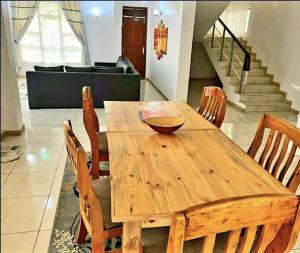 ein Holztisch und Stühle in einem Zimmer in der Unterkunft Mara Home 2 in Arusha