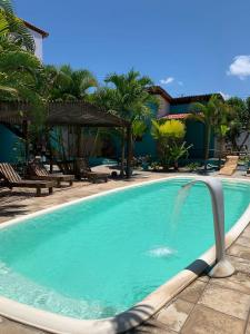 - une piscine avec une fontaine dans un complexe dans l'établissement Hawaii Flats, à São Miguel do Gostoso