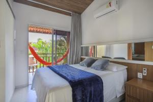 a bedroom with a bed with a blue blanket on it at Flat Solar Água- by Pipa Praia House in Pipa +26 photos