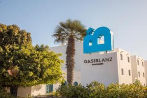 a building with a palm tree in front of it at Oasis Lanz Beach Mate in Costa Teguise