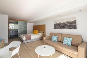 a hotel room with a couch and a bed at Oasis Lanz Beach Mate in Costa Teguise