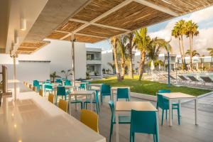a restaurant with tables and chairs and palm trees at Oasis Lanz Beach Mate in Costa Teguise +37 photos