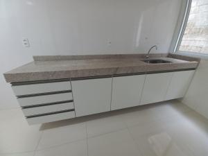 a white kitchen with a sink and a window at Apartamento central in Domingos Martins +13 photos