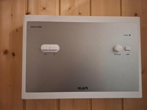 a white microwave on a wooden wall at Studio avec sauna privé in Châtel-Saint-Denis