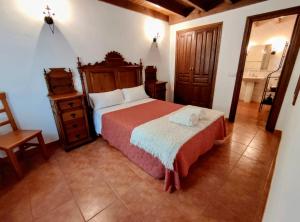 a bedroom with a bed and a dresser and a mirror at Apartamento Rural Rubó in Alles