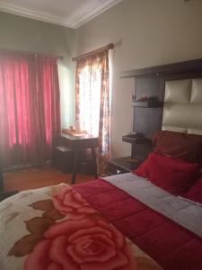 a bedroom with a bed with a rose on it at Town Charm Guesthouse in Germiston