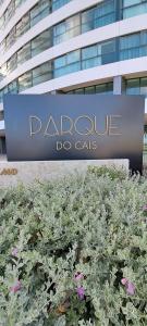 a sign in front of a building with flowers at Parque do Cais - Flats Premium no Recife por Yolo in Recife