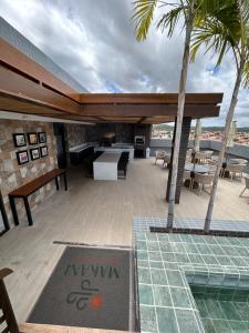 Un patio con mesa y sillas y una piscina. en Flat makani carneiros tamandare, en Tamandaré