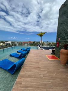 una fila de tumbonas azules en una piscina en Flat makani carneiros tamandare, en Tamandaré
