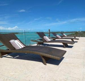 a row of chairs sitting on the beach at Las Brisas Azules in Providenciales