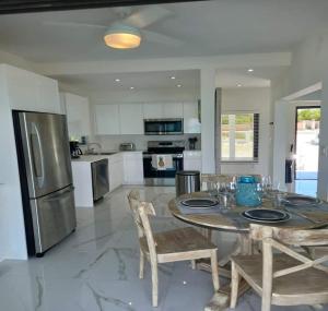 a kitchen with a table with chairs and a refrigerator at Las Brisas Azules in Providenciales