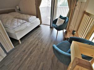 a bedroom with a bed and a chair and a table at Ferienhaus mit privater Sauna in Granzow