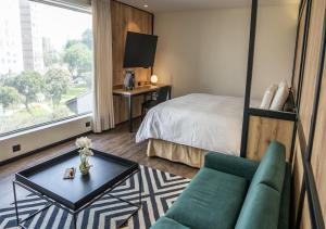 a hotel room with a bed and a couch and a table at LUOXO Hotel in Lima +53 photos
