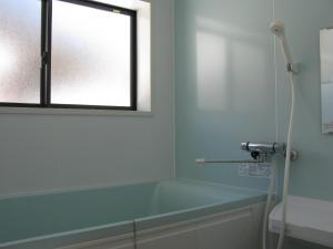 a bathroom with a bath tub and a window at Satoyama Guest House Couture in Ayabe +86 photos