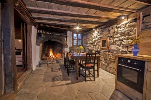 a dining room with a table and a fireplace at Authentic House with Stunning Mountain View - Karashka in Apriltsi