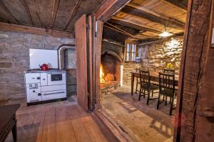 a kitchen and dining room with a stove and a fireplace at Authentic House with Stunning Mountain View - Karashka in Apriltsi +30 photos
