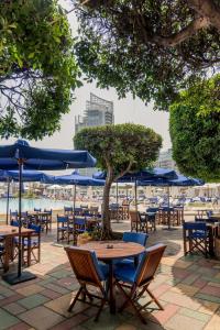 un gruppo di tavoli e sedie con ombrelloni blu di The View - Saint George Hotel a Beirut