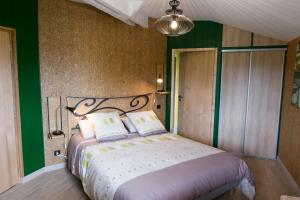 um quarto com uma cama grande e paredes verdes em Homgaïa chambres d'hôtes em Clisson